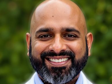 Smiling bald man with a full beard and mustache outdoors.