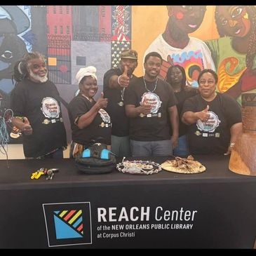 Group posing behind REACH Center table at New Orleans library.