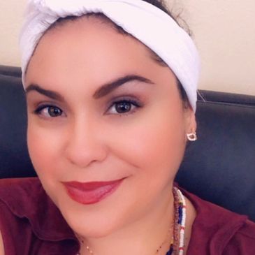 Woman with white headband smiling.