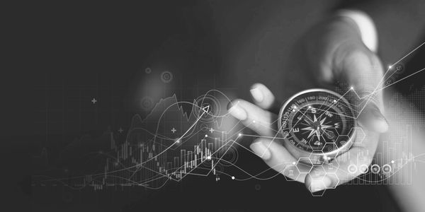 Hand holding compass with digital data and graphs overlay.