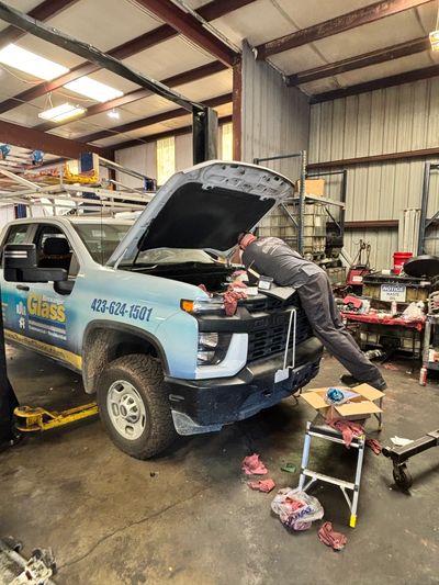 Mechanic working on a truck engine in a garage.