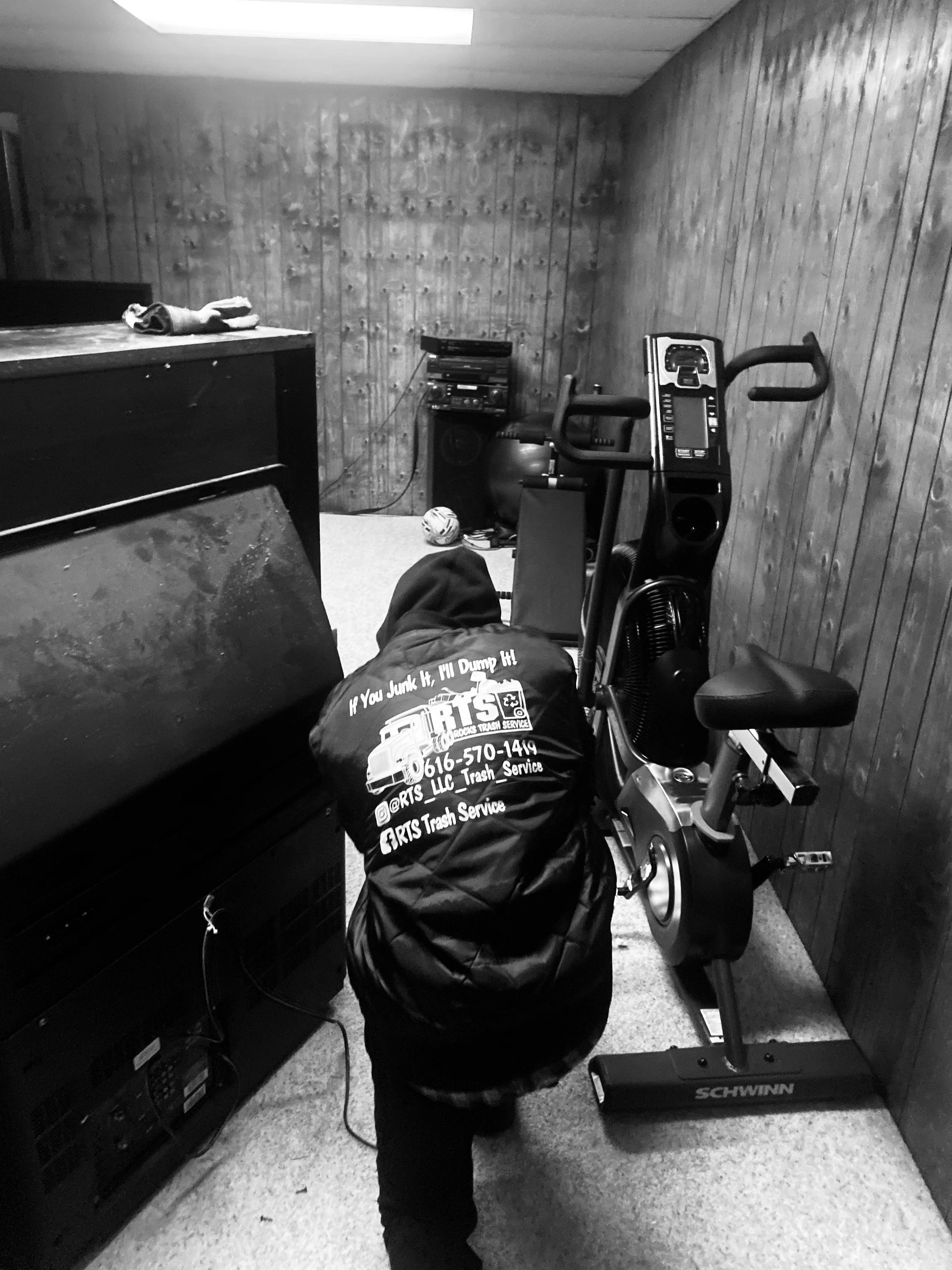 RTS Rocks Trash Service crew member removing furniture and exercise equipment during an indoor prope