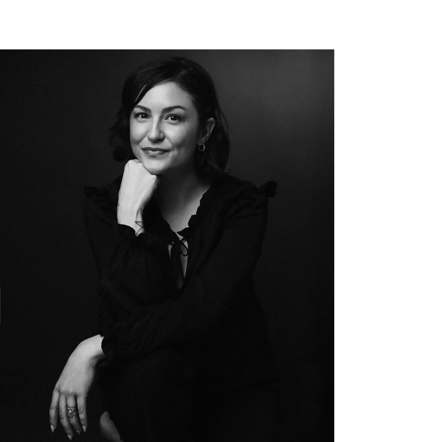 Black and white portrait of a woman with a confident smile.