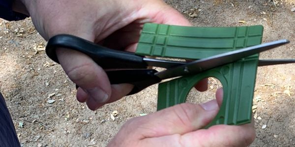 Gutter Stick Plate being cut to fit over downspout opening
