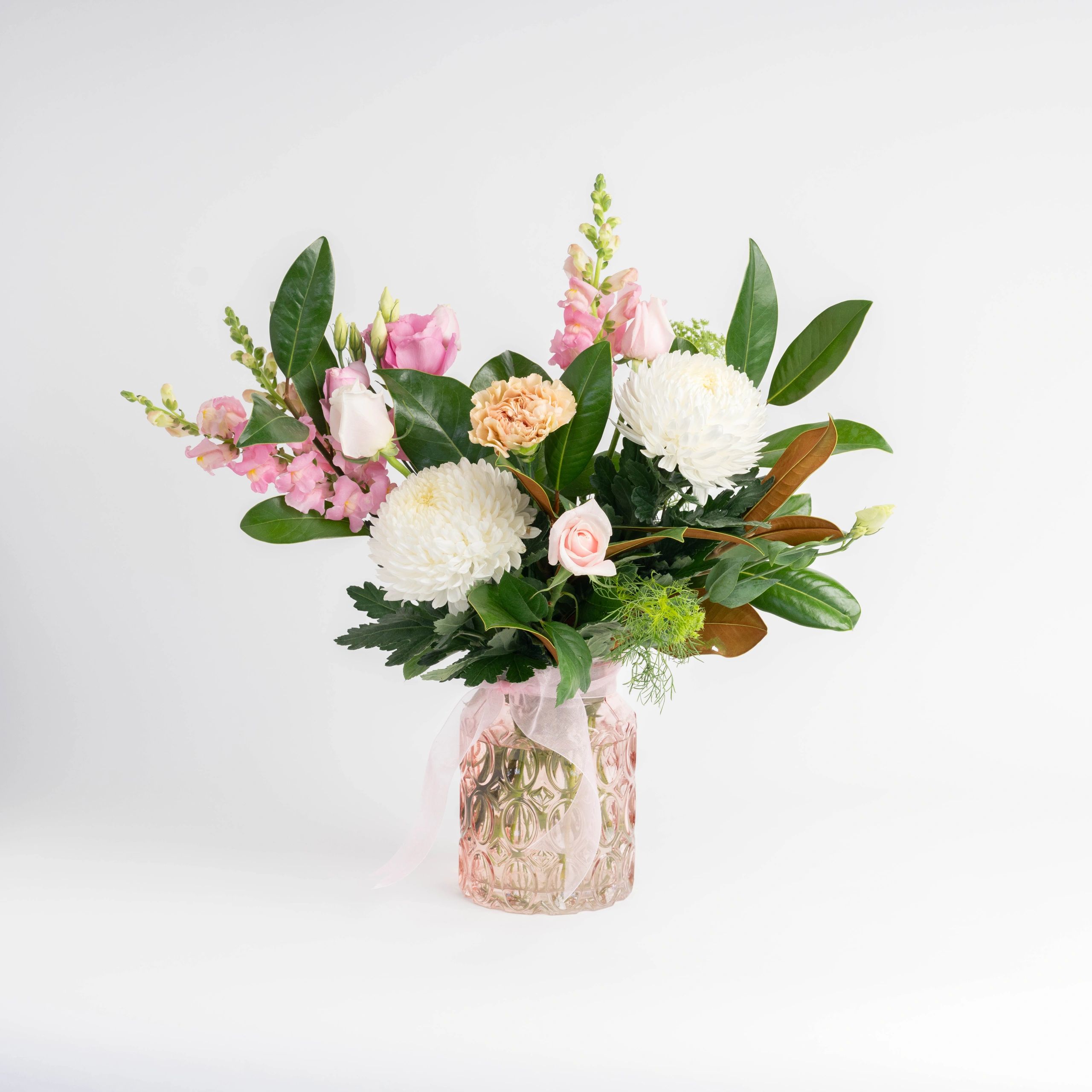 Elegant bouquet with white, pink, and peach flowers in a pink textured vase.