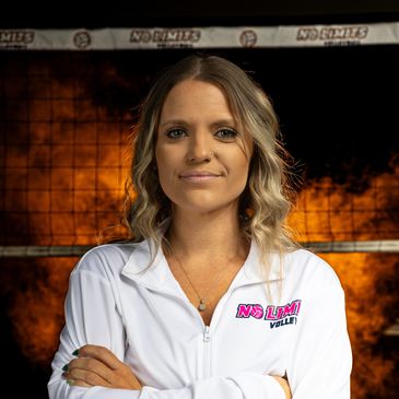 Confident female volleyball player standing with crossed arms.