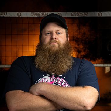 Man with a large beard and crossed arms.