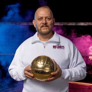 Man holding a golden volleyball in sports attire.