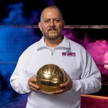 Man holding a golden volleyball, standing in front of colorful smoke.