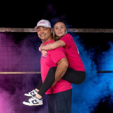 Man giving young woman a piggyback ride, both smiling.