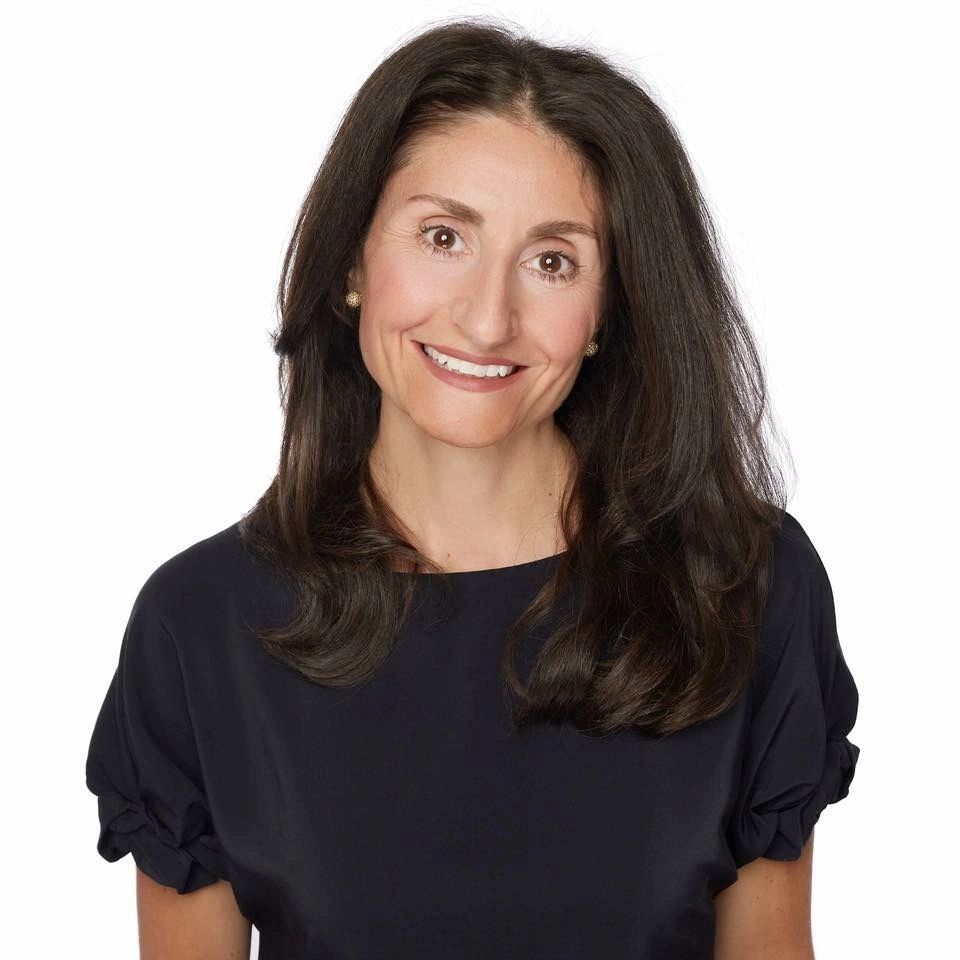 Smiling woman with dark hair wearing a black top.