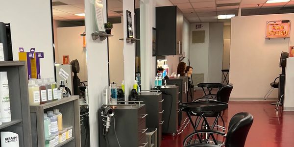 Interior of a clean, modern hair salon with styling stations and products.