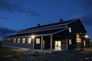 A large barn lit up at night.