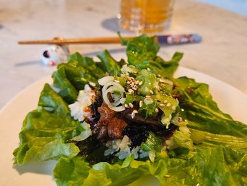 Korean lettuce wrap with marinated meat and rice.