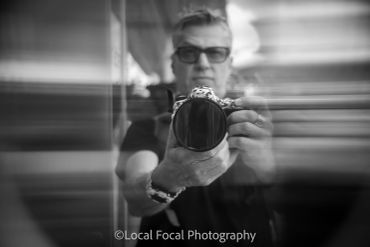 Blurred reflection of a man holding a camera.