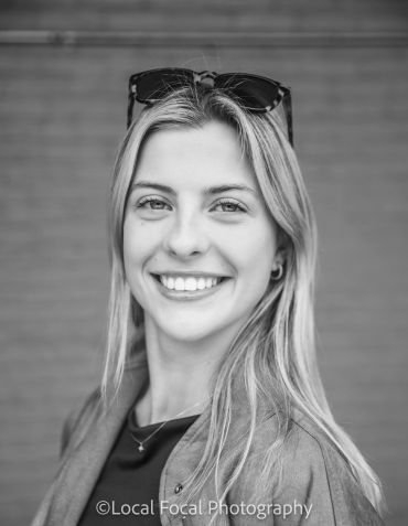 Smiling woman with sunglasses on her head.