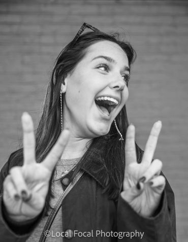 Happy woman making peace signs with both hands.