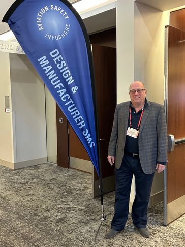 Man standing beside aviation safety banner.