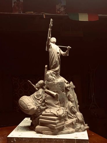 A clay sculpture depicting a dynamic scene with three figures and stairs.