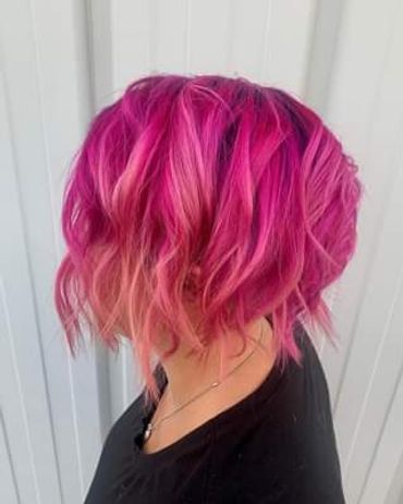 Vibrant pink and purple wavy bob hairstyle on a mannequin.