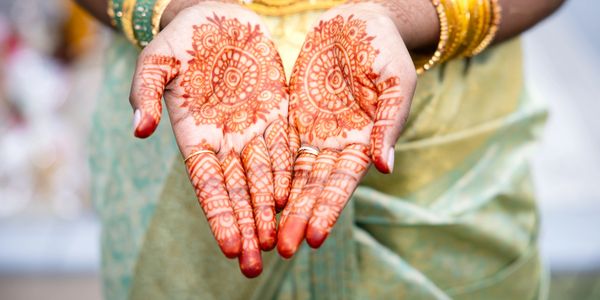 Hands decorated with intricate henna designs.