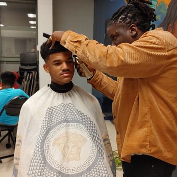 Our youth learning about the business of owning a barbershop from master barber, Devon Dey.