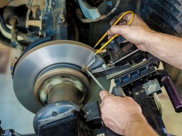 Car mechanic from Saskatoon's Tech 7 Auto Repair performs brake inspection and repair.