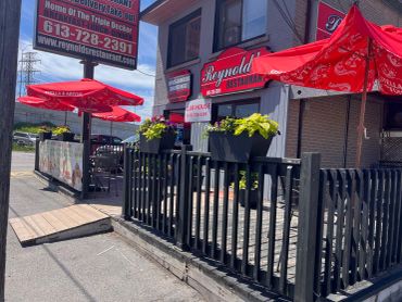 Outdoor dining area with red umbrellas at a restaurant.