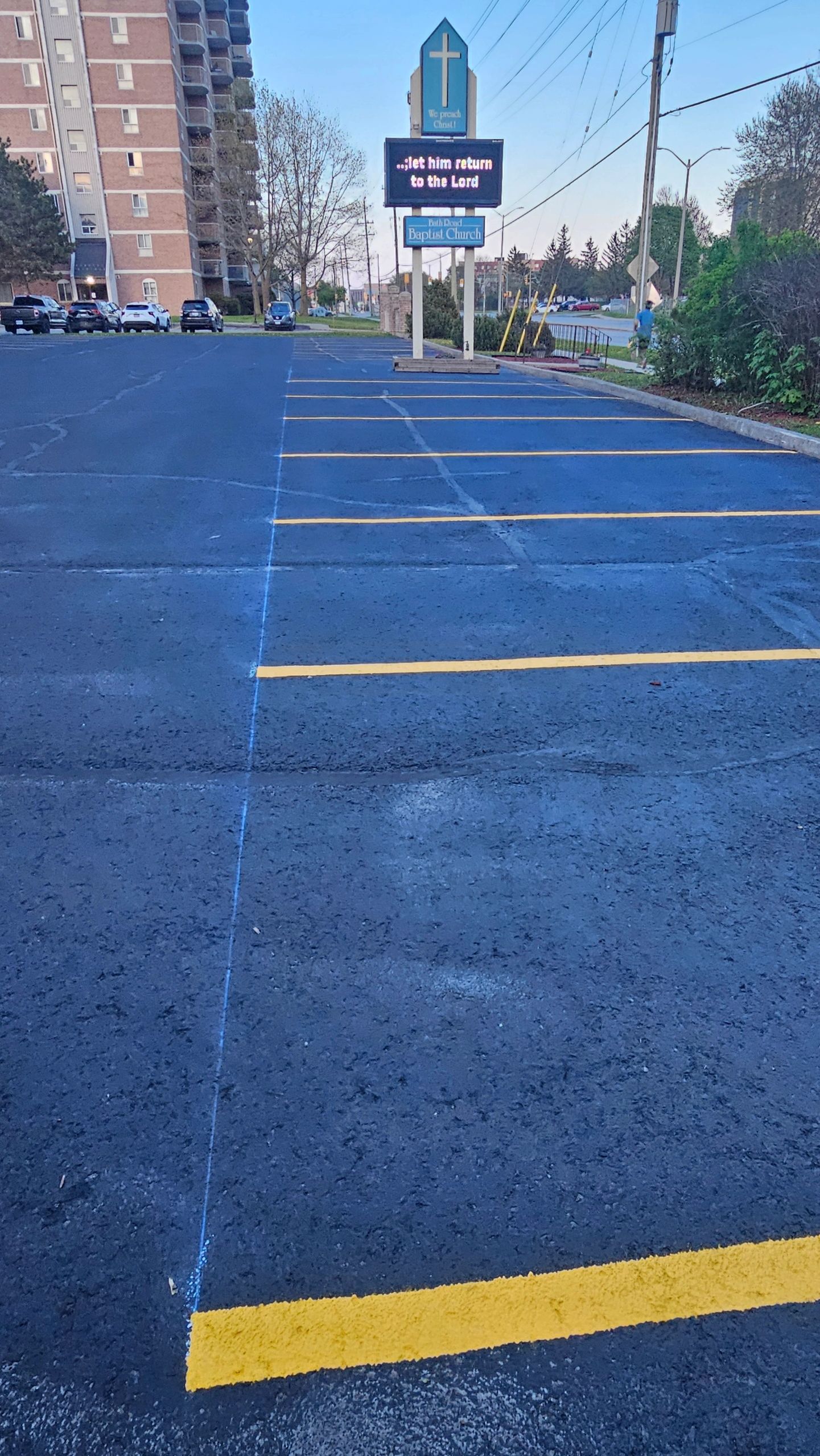 Empty parking lot in front of a Baptist church with a digital sign.