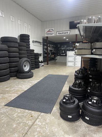 A tire and trailer parts shop interior with stacked tires and trailer components.