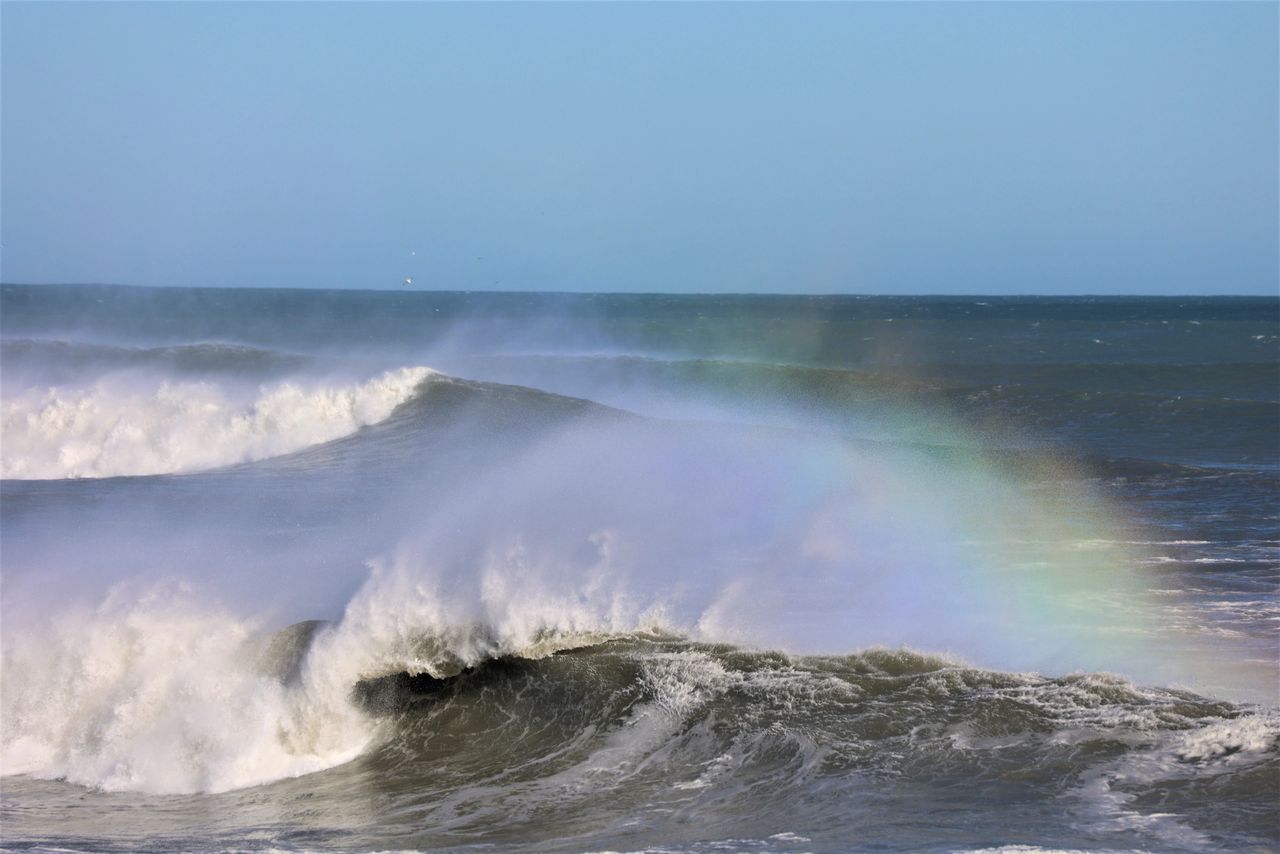 Wave with spray creating a rainbow