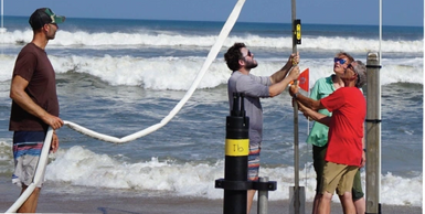 P Dickhudt (L), L Gorrell, N Stark, and S Elgar (R) jet a pipe to hold sensors at Duck, NC; Sep 2019