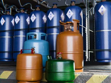 Various colored gas cylinders arranged in an industrial setting.
