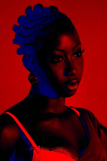 Portrait of a woman with dramatic red and blue lighting.