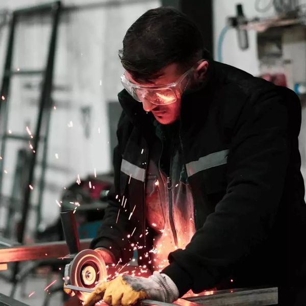 one of our skilled metal worker using an angle grinder to cut and shape steel in a professional work