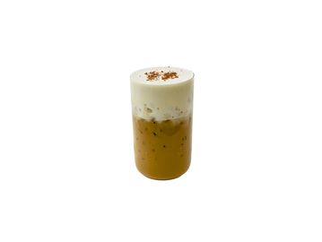 Iced coffee topped with creamy foam and sprinkled cinnamon.