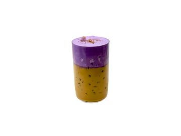A two-layered drink with purple and yellow colors in a transparent glass.