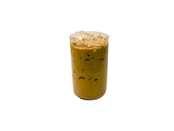 A glass of iced coffee with milk on a white background.