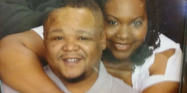 A joyful couple smiling closely together in a warm embrace.