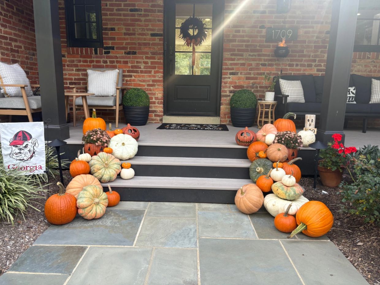 Front porch decorated with pumpkins and fall decorations.