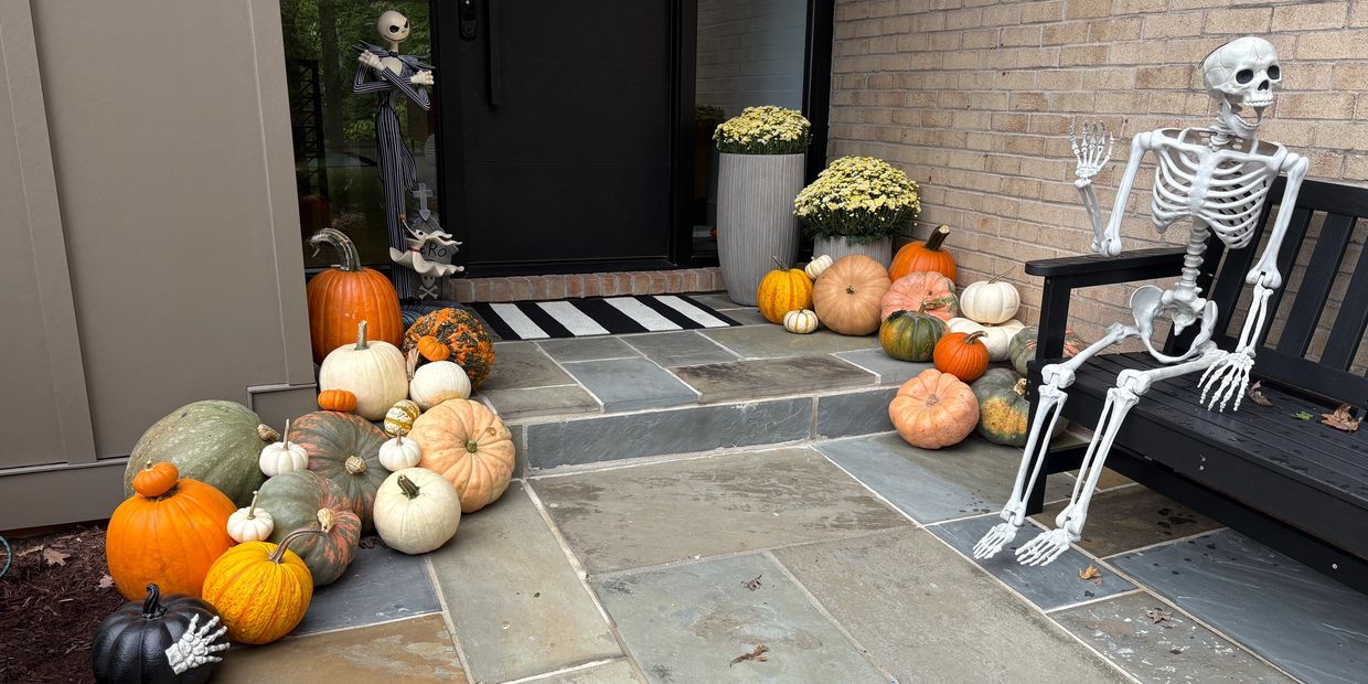 Halloween-themed porch with pumpkins and skeleton decorations.