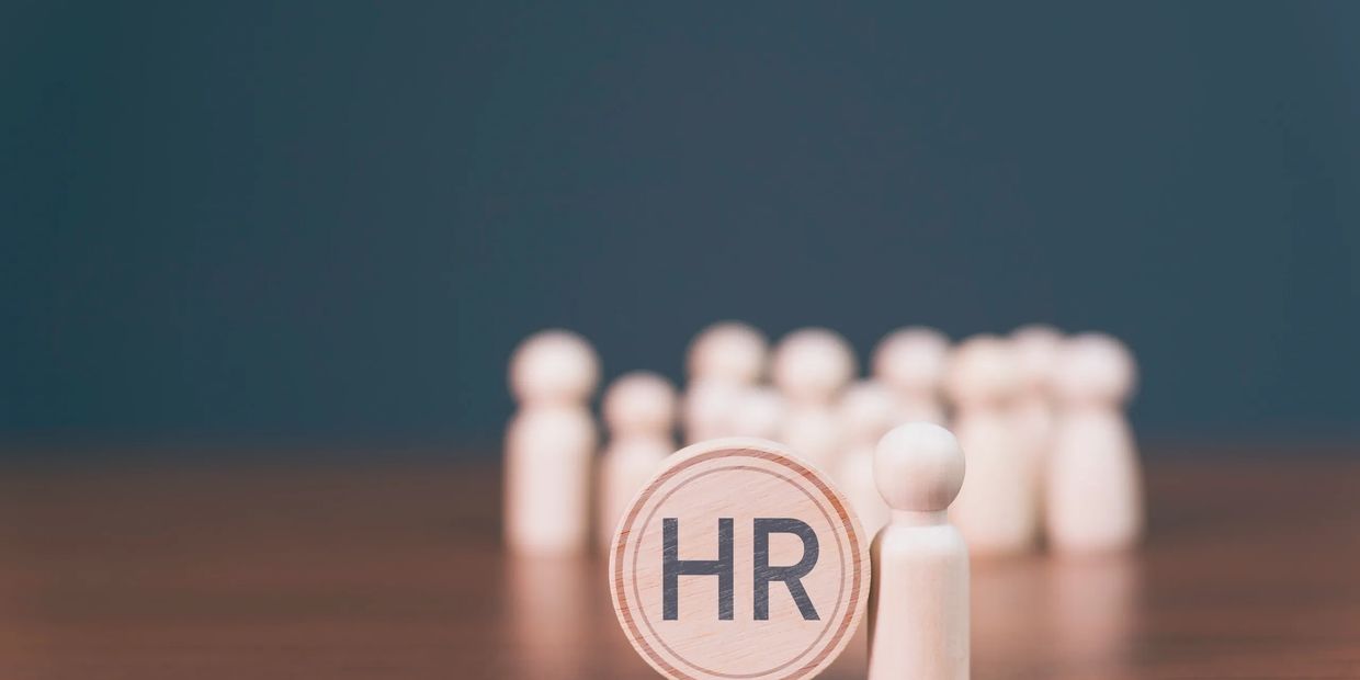Wooden figurines with an HR sign representing human resources management.