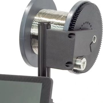 Spool of wire mounted on a device with a digital screen.