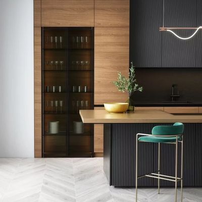 Modern kitchen with wood cabinetry, black accents, and a teal bar stool.