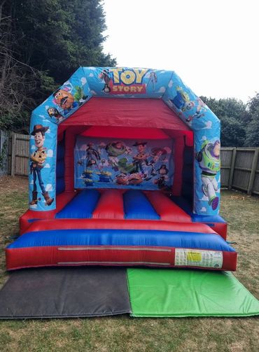 Toy Story-themed inflatable bounce house outdoors.