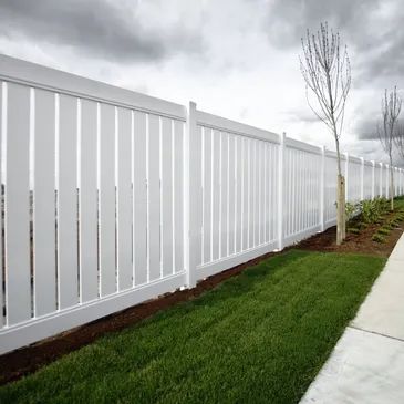 A fresh white fence frames the landscape with clean lines, adding curb appeal and a touch of classic