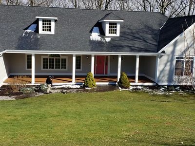 Grey house with black roof and new gutters