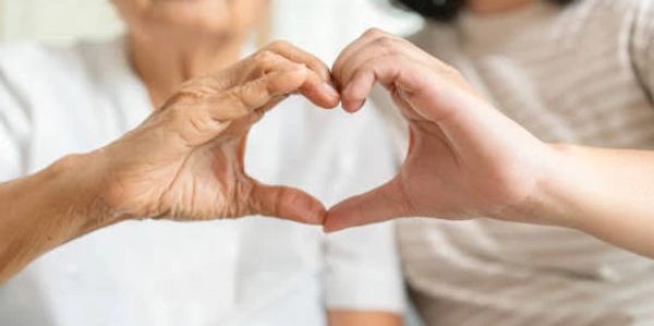 Two hands forming a heart shape together symbolizing love and connection.