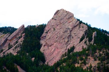 Steep rocky mountain with trees.