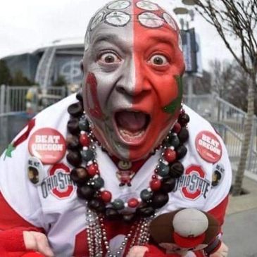 Excited Ohio State football fan with face paint and beads.
